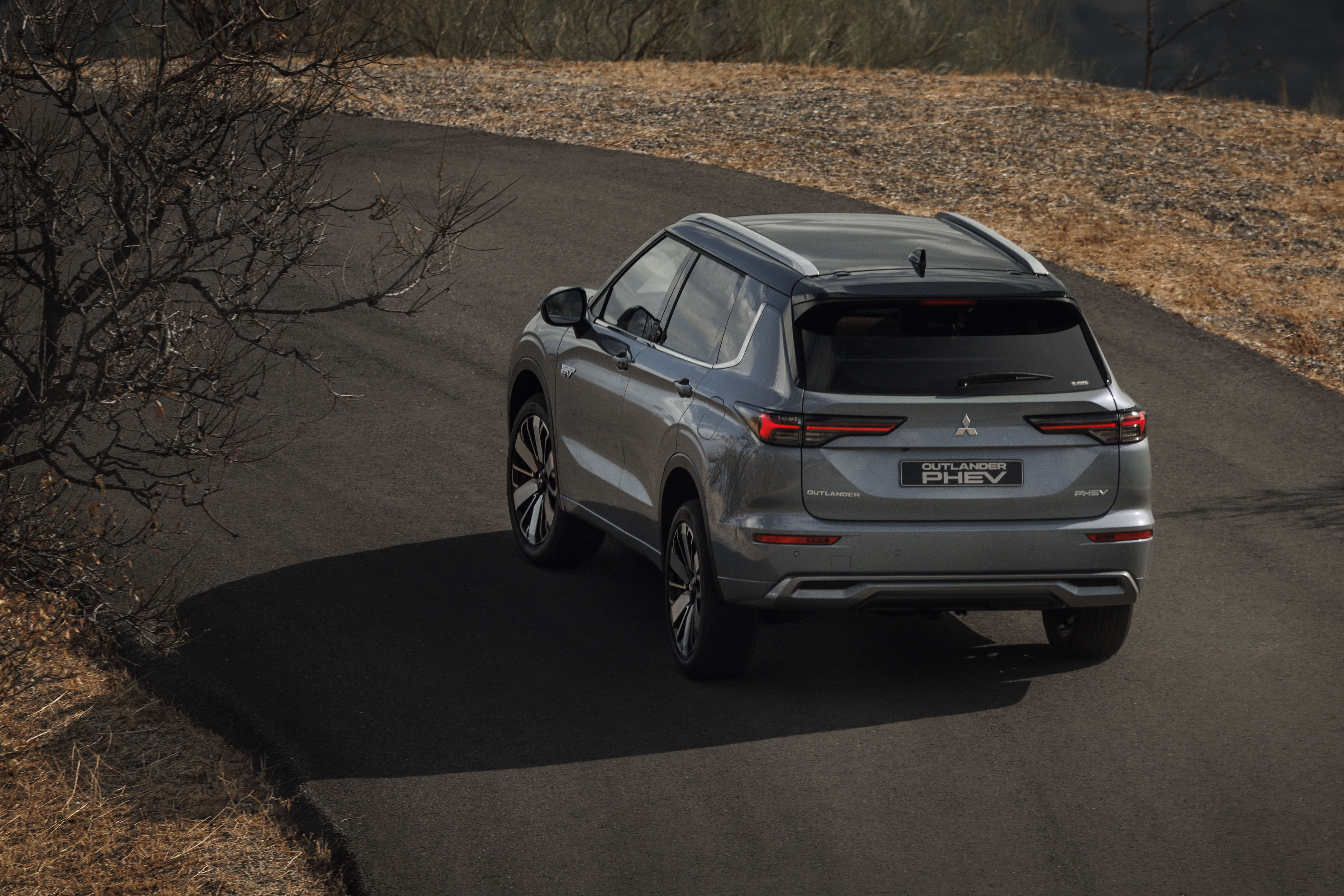 Mitsubishi Outlander PHEV MY2025 in woestijn met wolkenlucht
