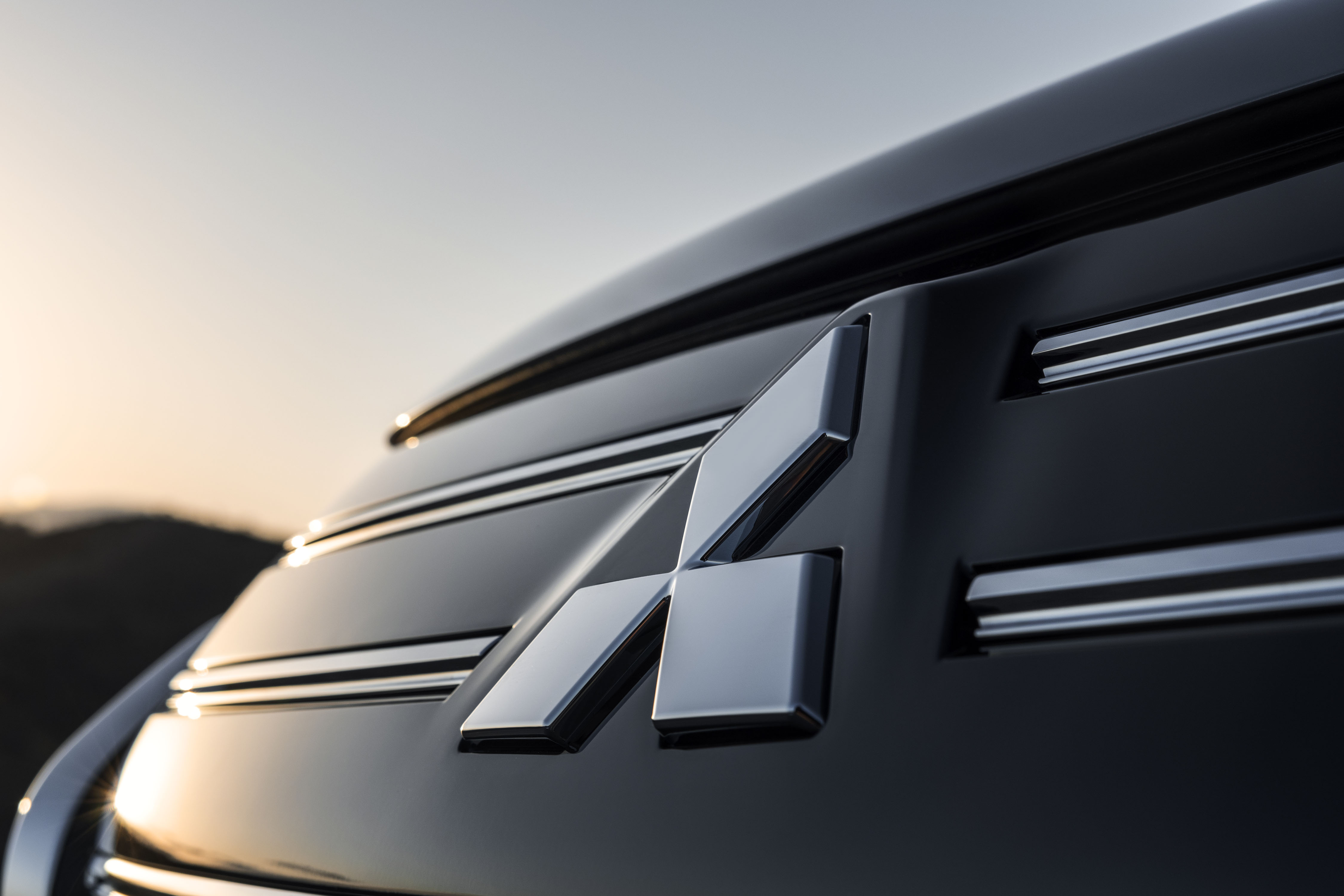 Mitsubishi Outlander PHEV MY2025 in woestijn met wolkenlucht