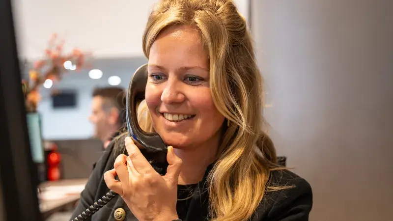 Esther achter de balie aan de telefoon